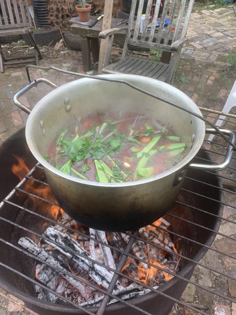 veggie stew cooking on a fire
